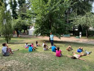 Bambini sdraiati sull’erba del parco Belvedere durante un gioco sensoriale